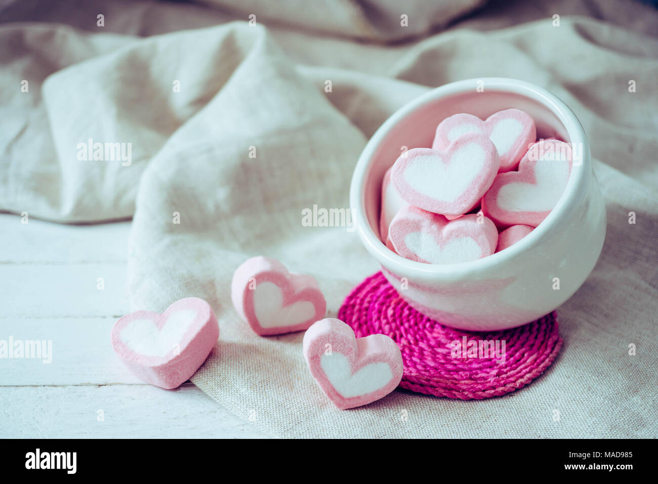 Forma di cuore marshmallows in tazza bianca su sfondo legno, dolce e concetto di amore Foto Stock