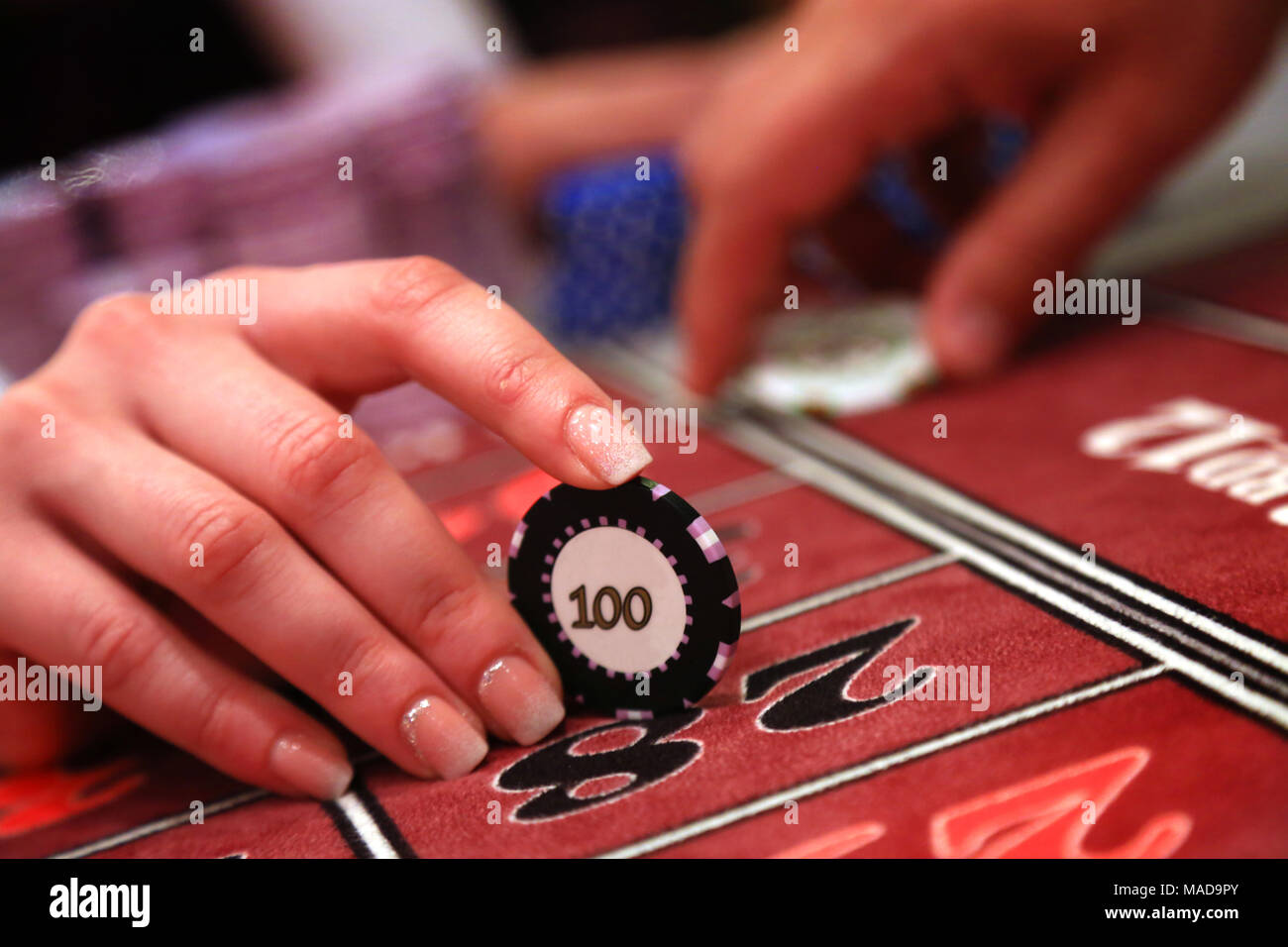 Casino giocatore in possesso di un chip di nero, primo piano Foto Stock