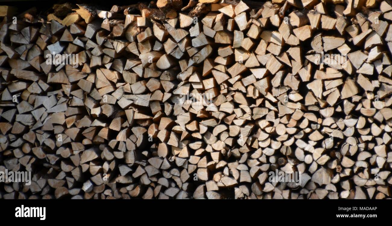 Pila di tronchi di legno di fronte a una casa, può essere utilizzata come sfondo o texture Foto Stock