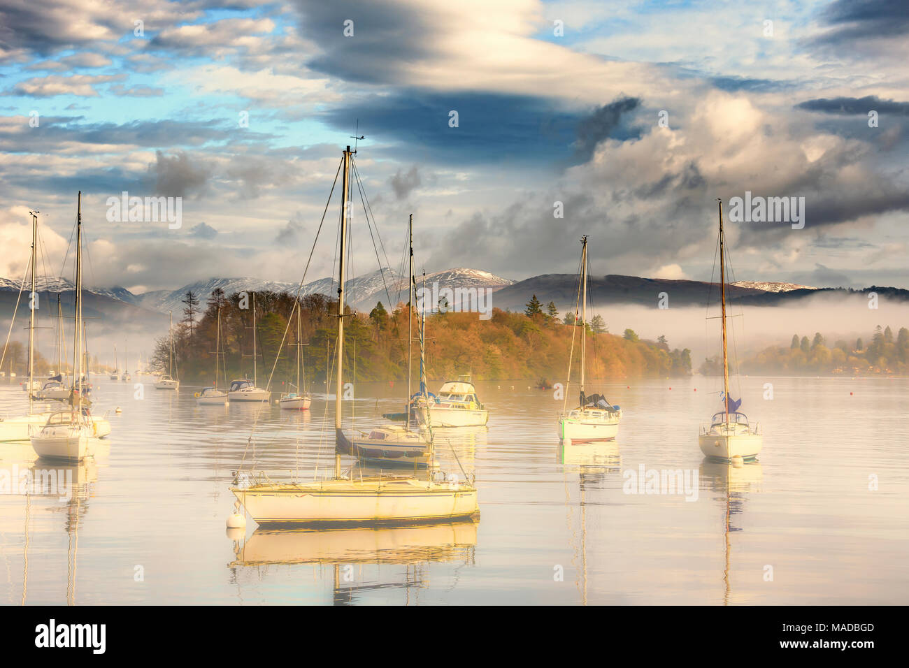 Il Parco nazionale del Lake District. Cumbria. La sponda occidentale di Windermere guardando dal traghetto dock. Nebbia mattutina con barche in primo piano. Foto Stock