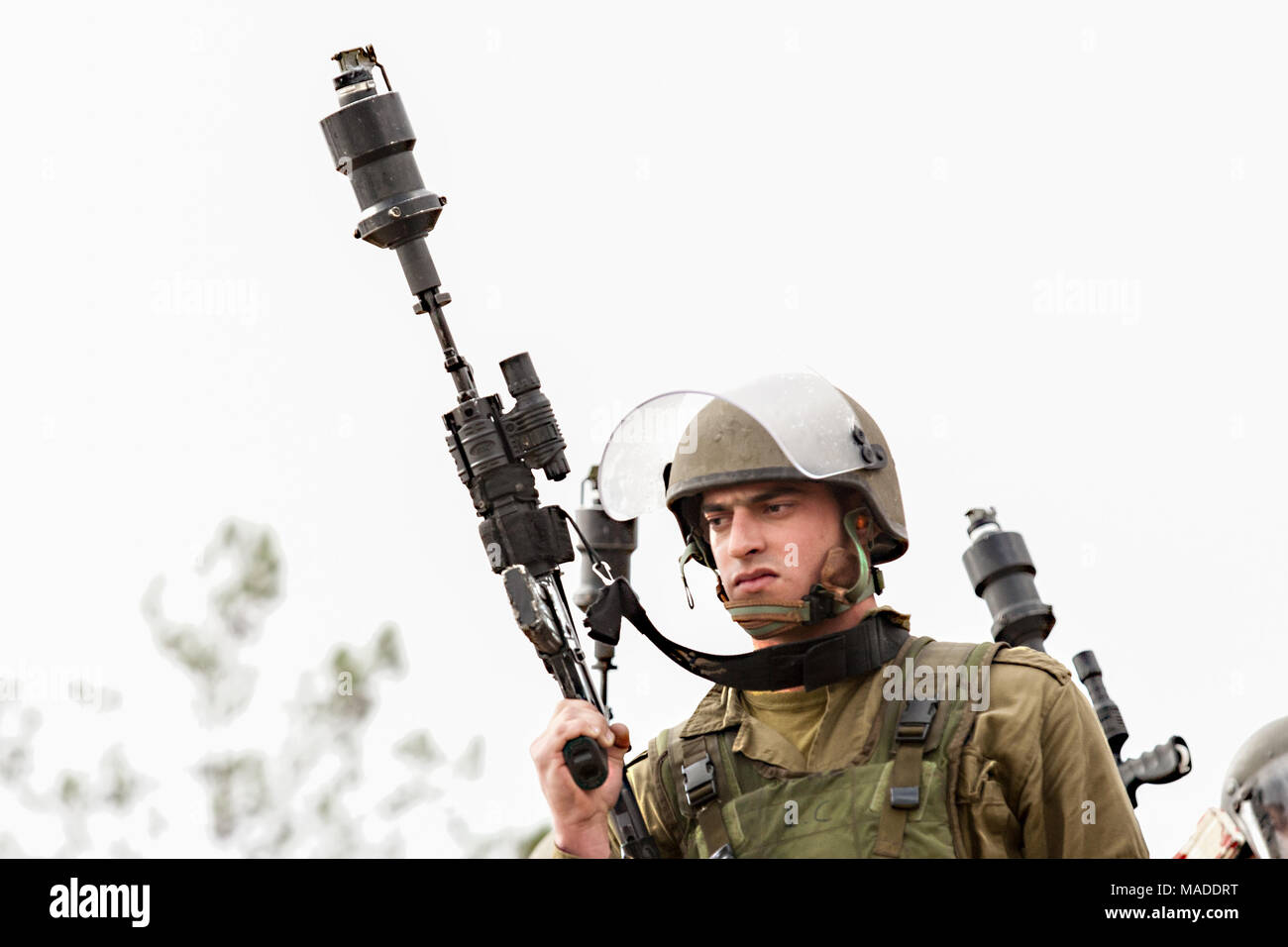 Bilin, Palestina, Dicembre 31, 2010: Israele Defense Force soldato è sempre pronto a sparare gas lacrimogeni durante settimanalmente manifestazioni palestinesi contro Foto Stock