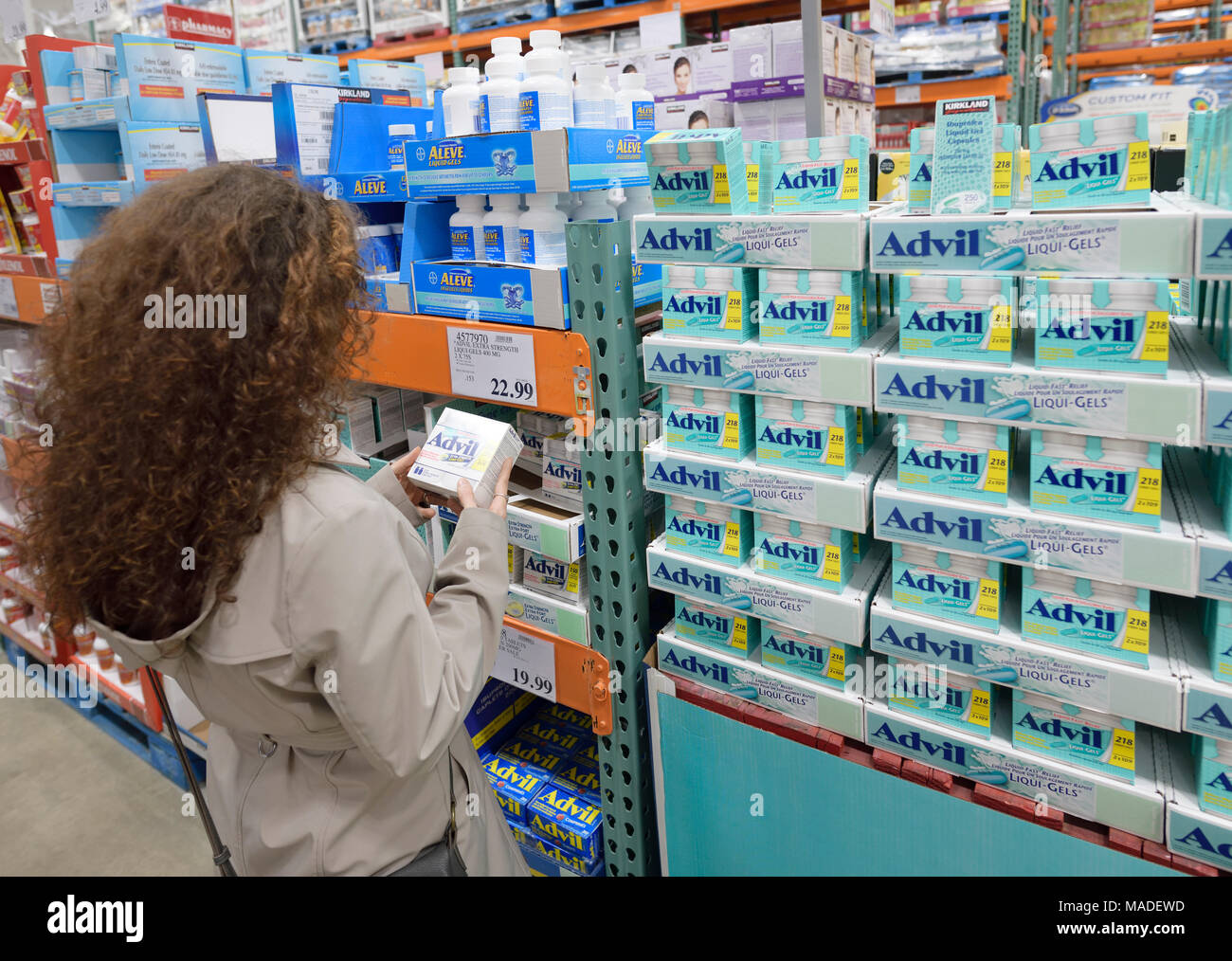 La donna il prelievo di una confezione di Advil liqui-gel sollievo dal dolore farmaci a Costco Wholesale magazzino di appartenenza store sezione farmacia. British Columbia, può Foto Stock