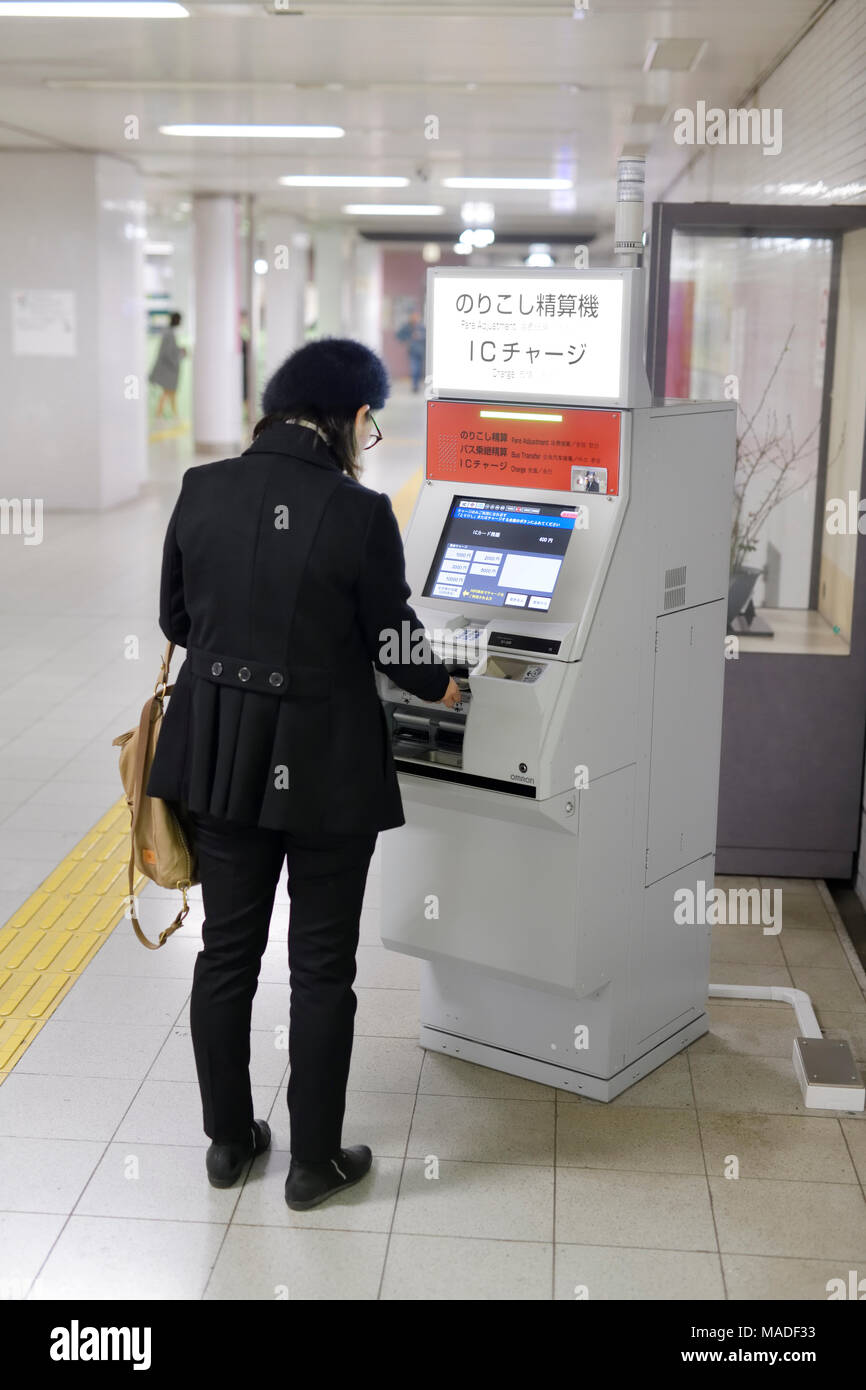 Donna che utilizza un adeguamento della tariffa la macchina a una stazione della metropolitana a pagare il supplemento di tariffa di pendolarismo, Kyoto, Giappone 2017 Foto Stock