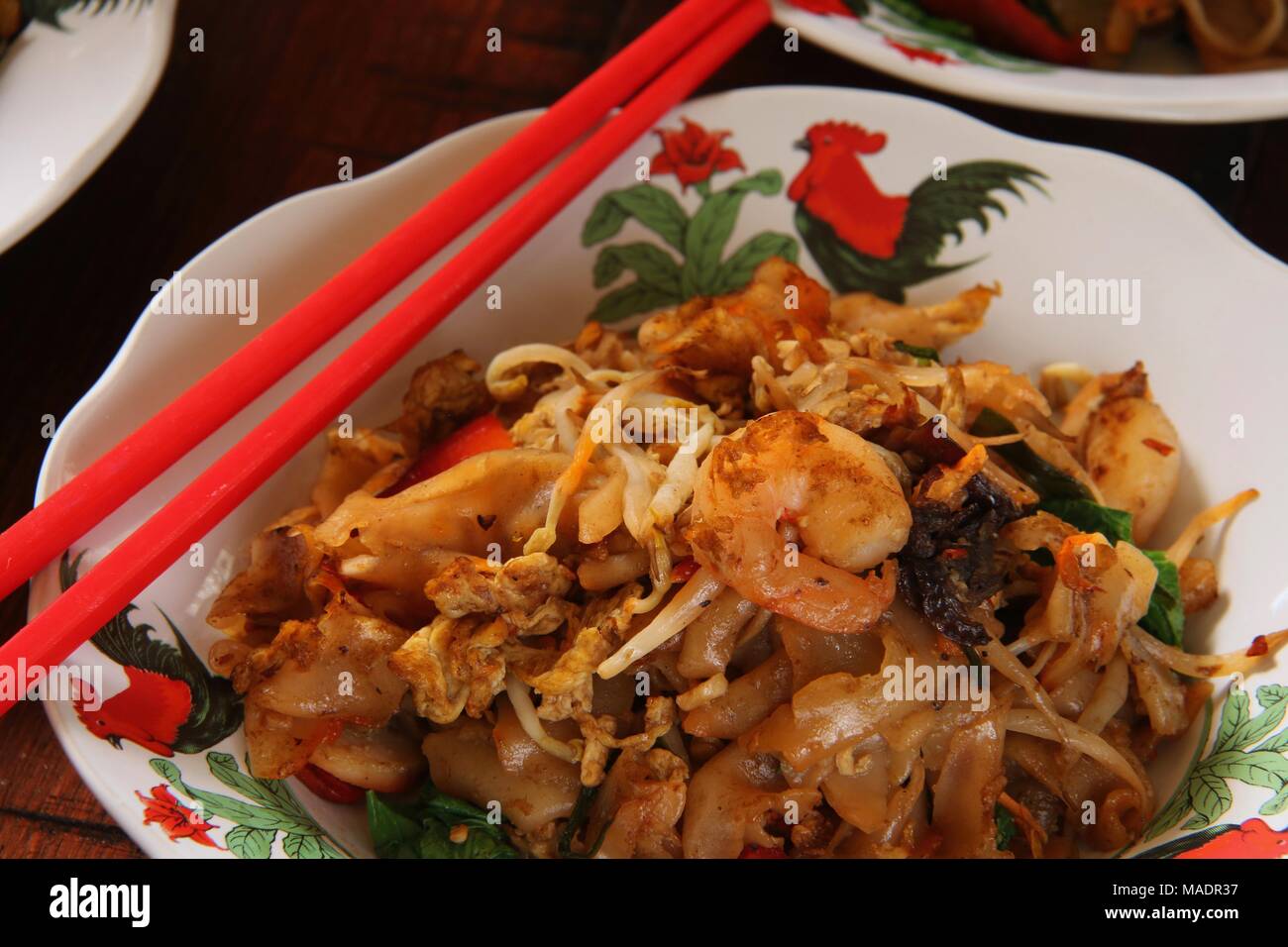 Fried Kway Teow, una strada popolare piatto di cibo di stir-fried piatto spaghetti di riso con pesce e frutti di mare, verdure e salsa di soia a Medan, nel nord di Sumatra. Foto Stock