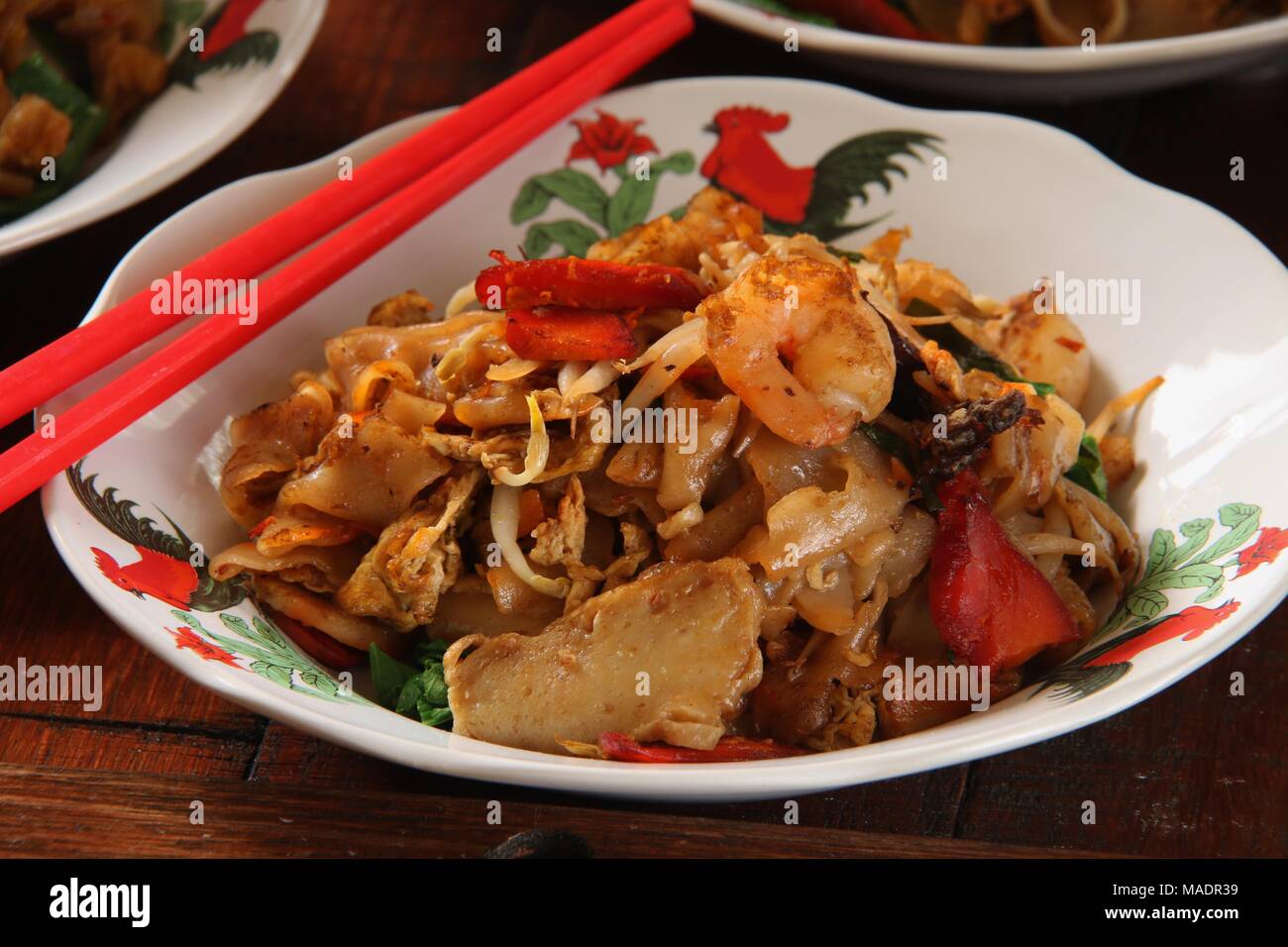 Fried Kway Teow, una strada popolare piatto di cibo di stir-fried piatto spaghetti di riso con pesce e frutti di mare, verdure e salsa di soia a Medan, nel nord di Sumatra. Foto Stock