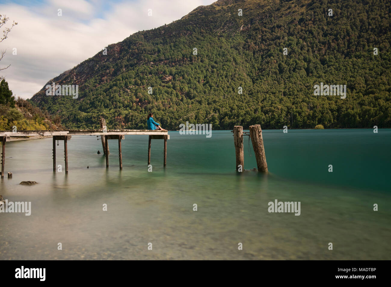 Seduto sul molo al Bob's Cove, sul lago Wakatipu, Queenstown, New Zealand Nuova Zelanda Foto Stock