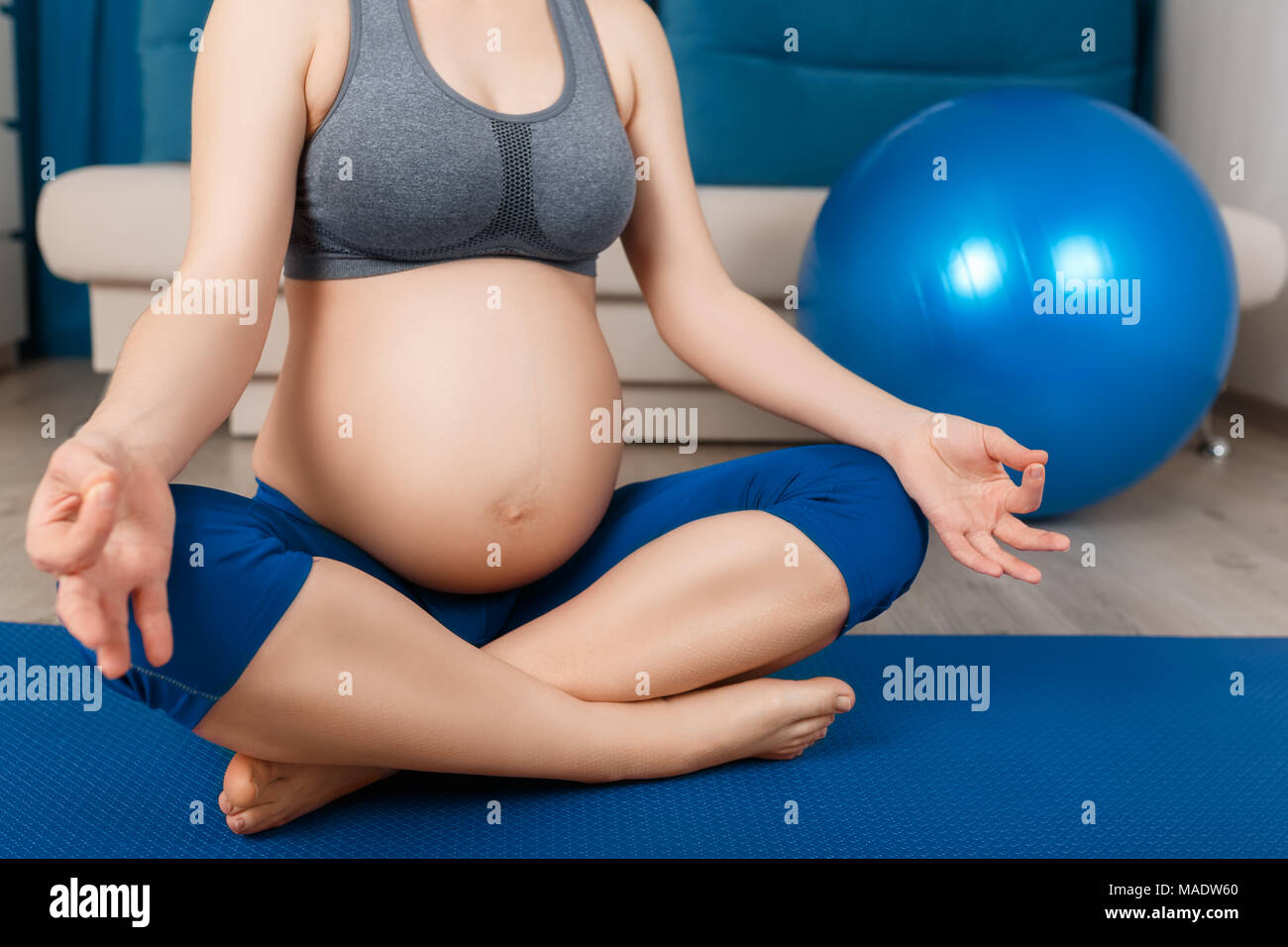 Closeup donna incinta facendo esercizi yoga a casa. Donna incinta medita. Gravidanza gravidanza lo yoga, relax, uno stile di vita sano concetto Foto Stock