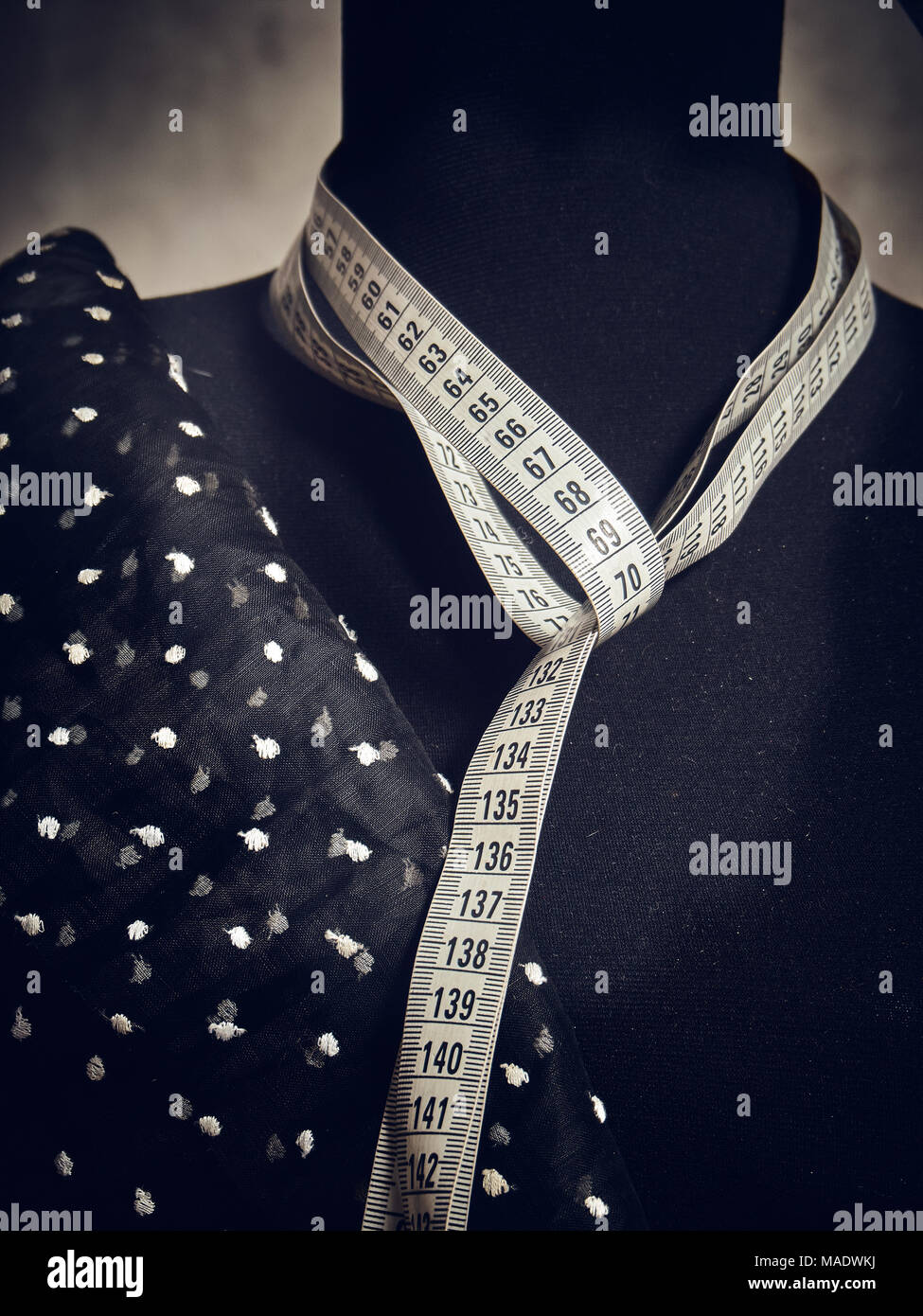 Un dummy per il montaggio e la convenienza di sartoria, sul collo del quale un nastro di misurazione è legato, un pezzo di stoffa è gettato sul lato. Foto Stock