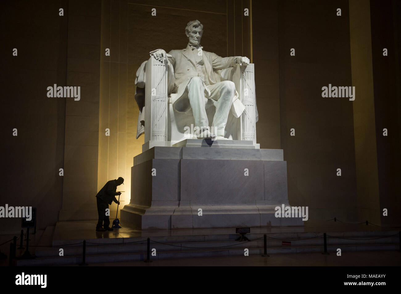 Washington, DC, Stati Uniti d'America. Il 1 aprile, 2018. Un lavoratore di manutenzione mops fino intorno alla base della statua del presidente Abraham Lincoln nel pre-alba ore prima il quarantesimo Pasqua annuale servizi Sunrise sui gradini del Lincoln Memorial. Questo evento è cominciato nel 1979 con un piccolo gruppo di persone ed è cresciuto fino a diventare uno dei più grandi di Pasqua preghiera sunrise servizi negli Stati Uniti, che richiama gente da Washington, DC area così come da tutto il mondo. Asta Lamkey Jr./Alamy Live News Foto Stock