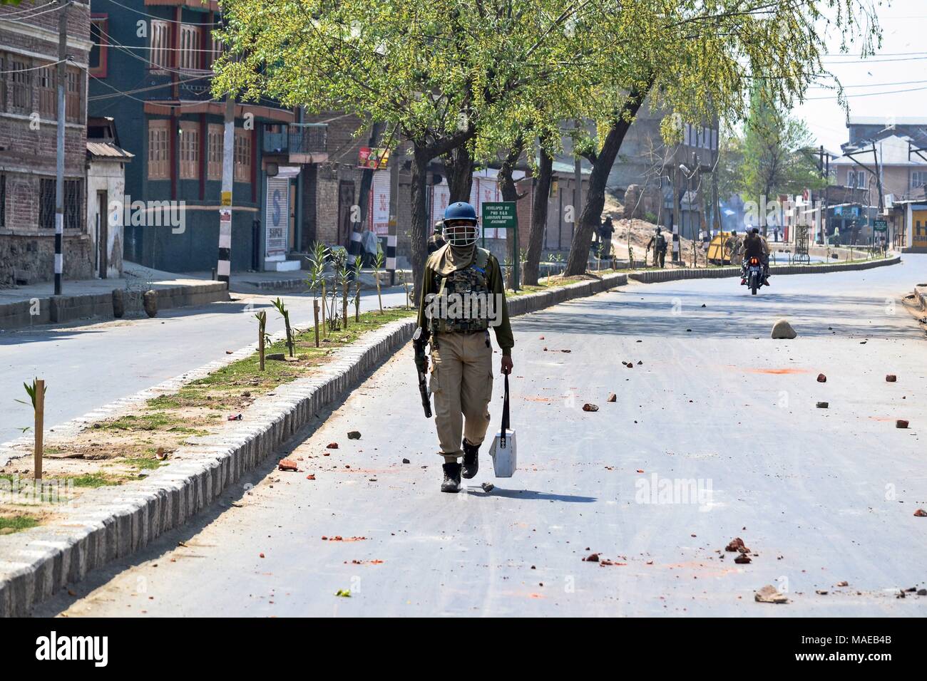 Srinagar, India. 1 apr, 2018. Un indiano trooper paramilitari passeggiate durante scontri a Srinagar, Indiano Kashmir amministrato. Otto militanti sospetti e 2 indiano esercito di uomini sono stati uccisi in incontri separati nel sud del Kashmir. Due civili sono stati anche uccisi e decine di altri feriti negli scontri scoppiati tra i manifestanti e forze di sicurezza seguenti tre incontri separati in diverse parti del Kashmir. I separatisti hanno chiamato per una chiusura il lunedì contro le uccisioni. Credito: Saqib Majeed SOPA/images/ZUMA filo/Alamy Live News Foto Stock