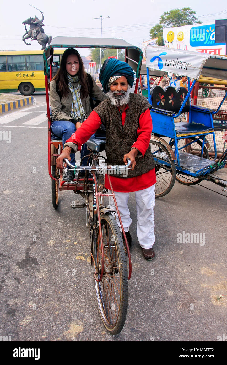 Local uomo alla guida di pedicab con un turista in Agra, Uttar Pradesh, India. Agra è una delle più popolose città in Uttar Pradesh Foto Stock