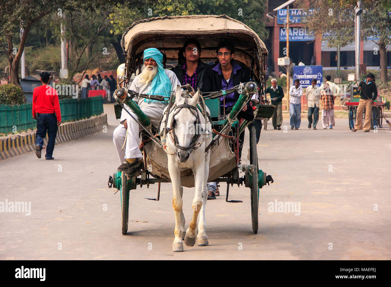 Persone in sella a un cavallo carrello in Agra, Uttar Pradesh, India. Agra è una delle più popolose città in Uttar Pradesh Foto Stock