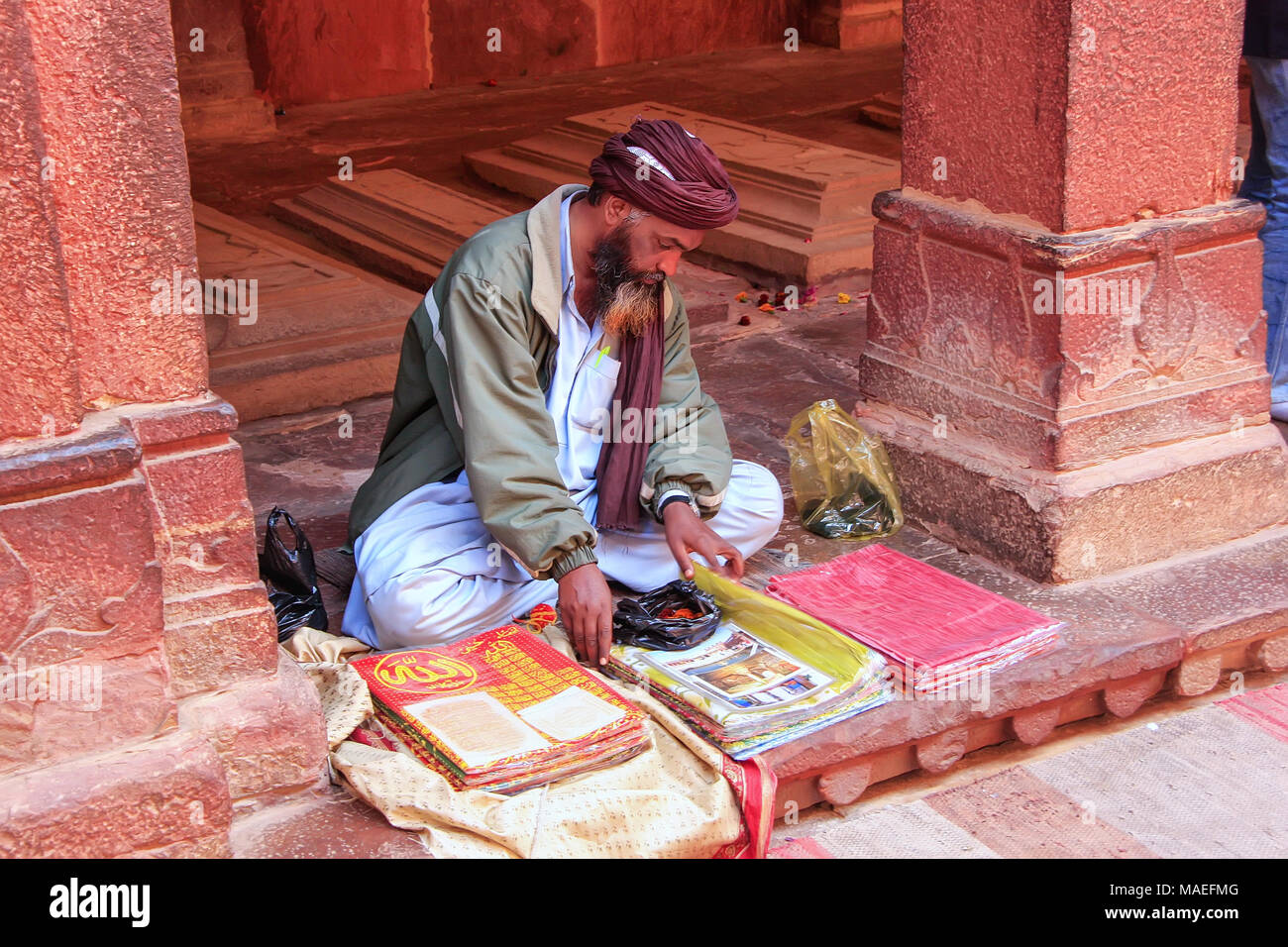 Uomo locali vendono merci nel cortile della Jama Masjid in Fatehpur Sikri, Uttar Pradesh, India. La moschea è stata costruita nel 1648 dall'imperatore Shah Jahan un Foto Stock