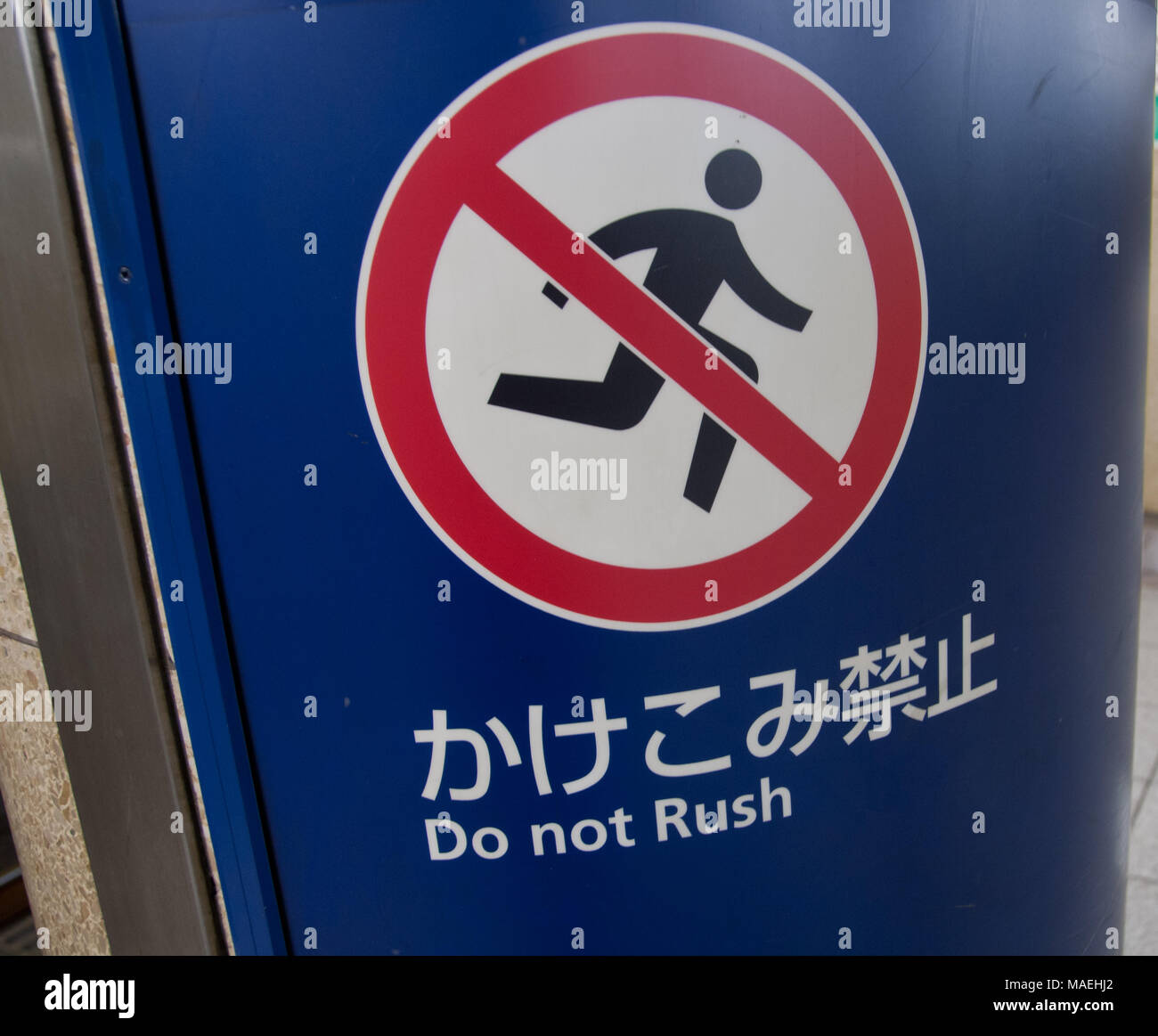 Un avviso di non affrettarsi in giapponese a Tokyo Giappone Foto Stock