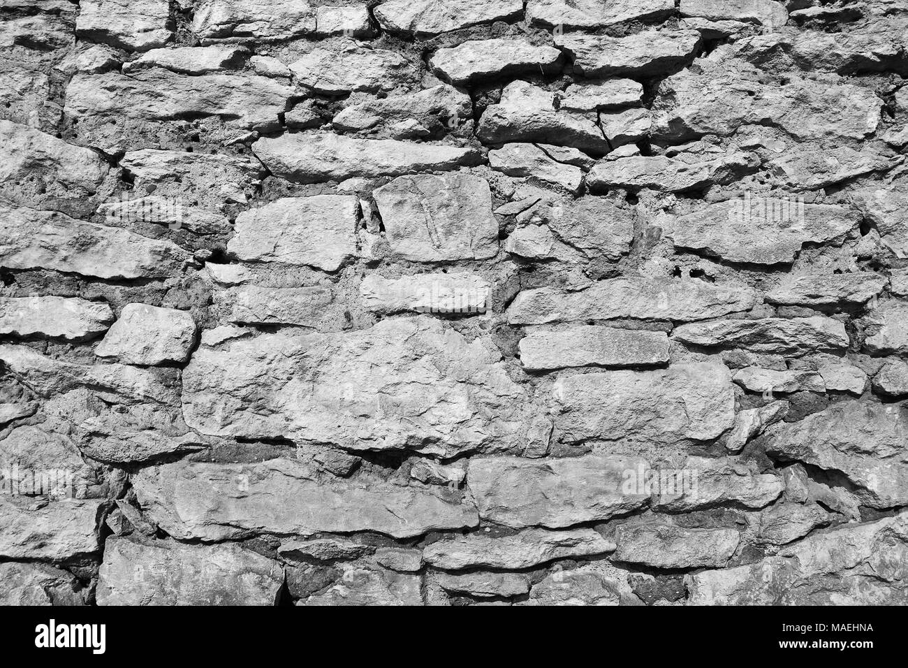 In bianco e nero la texture del vecchio muro di pietra Foto Stock