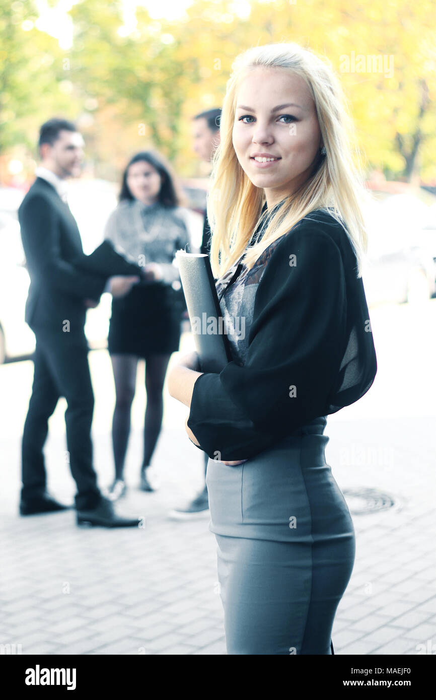 Giovane donna di affari con appunti in piedi all'aperto nei pressi di office Foto Stock