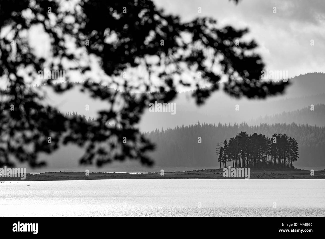 Piccola isola con strati di sfondo di montagna Foto Stock
