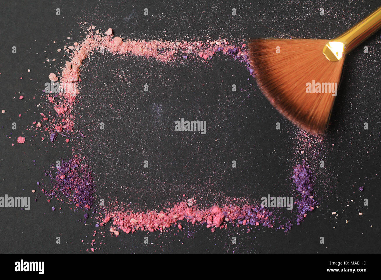 Close up. frame per il testo con i pennelli per il make-up e granelli di polvere su uno sfondo nero Foto Stock