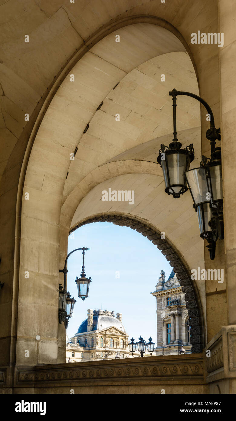 Parigi, Francia - 14 Marzo 2018: vista del padiglione Richelieu del palazzo del Louvre a Parigi tra gli archi del Guichets Lesdiguieres con vintage Foto Stock