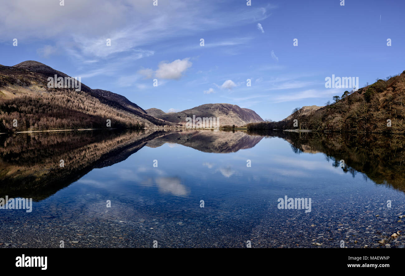 Guardando verso il lato nord della Buttermere con Melbreak perfettamente riflessa su un croccante di mattina di primavera Foto Stock