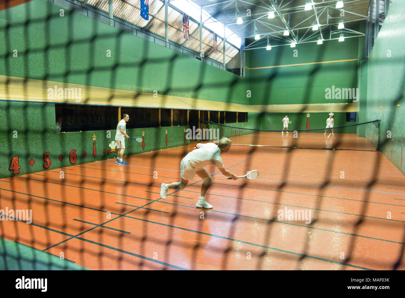 Vero e proprio campo da tennis con i giocatori in azione. Foto Stock