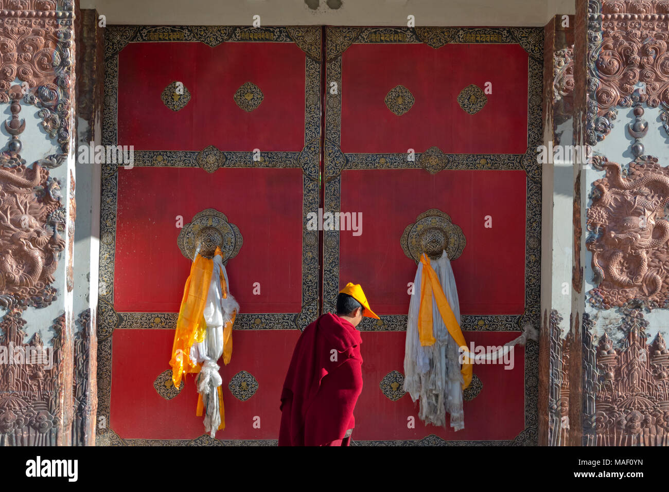 Monaco tibetano da passeggiate porta rossa del monastero Tagong, Tagong, western Sichuan, Cina Foto Stock