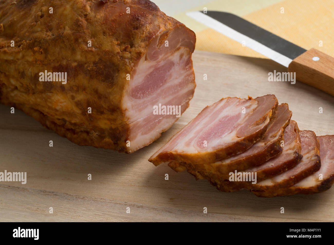 Pezzo di bacon arrosto e sottili fette di taglio Foto Stock