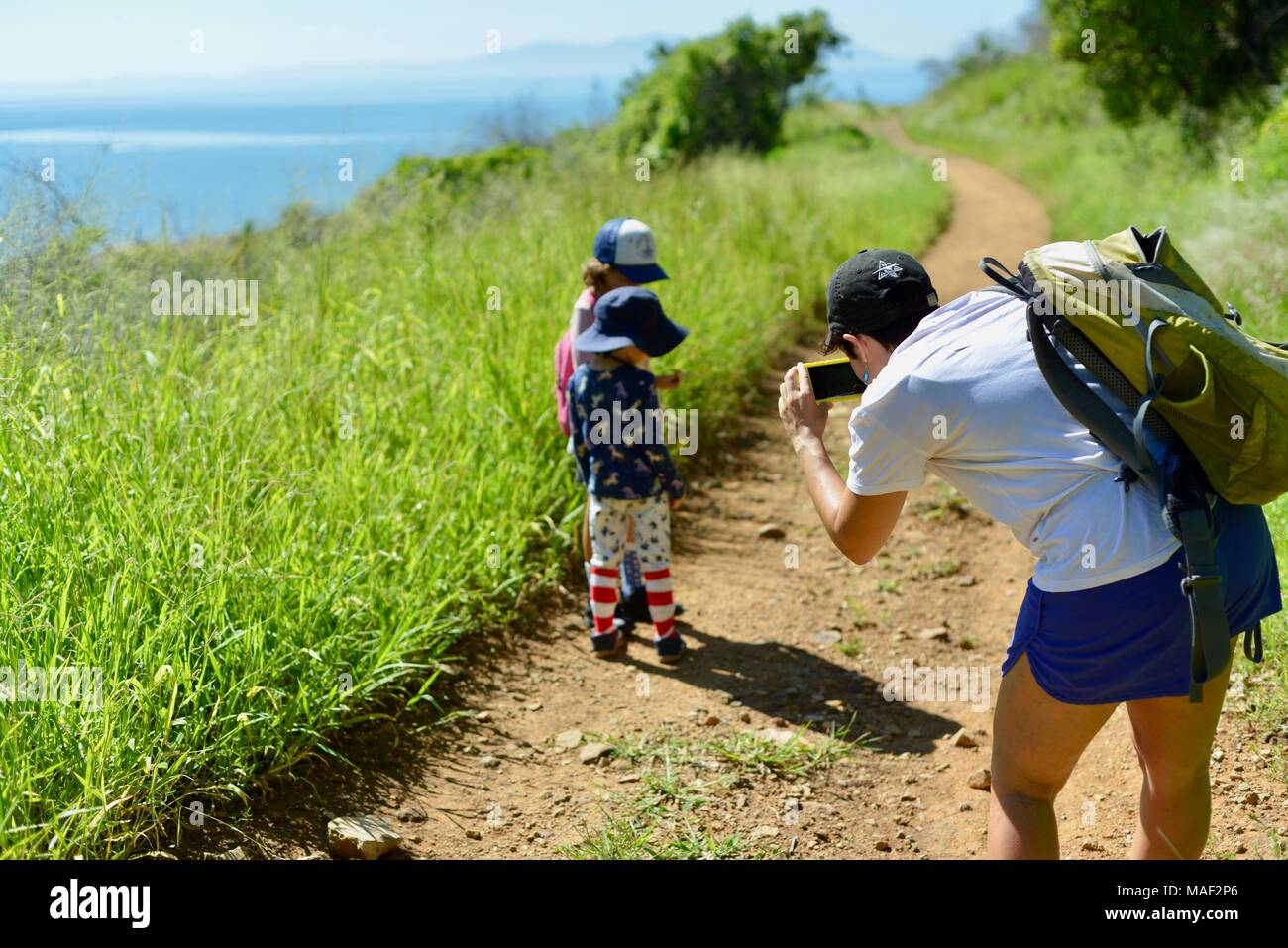 Madre di scattare una foto di bambini con telefono cellulare sul viaggio di famiglia, Shelly Cove trail a Cape Pallarenda Conservation Park Queensland Australia Foto Stock