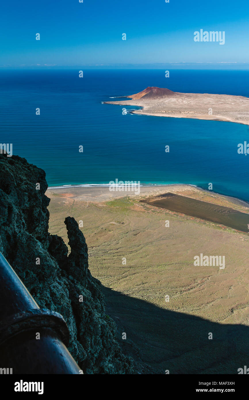 La vista dal Mirador del Rio a Lanzarote, Spagna alla Isla La Graciosa con il vulcano Montana Amarilla il alta scogliera in primo piano. Foto Stock