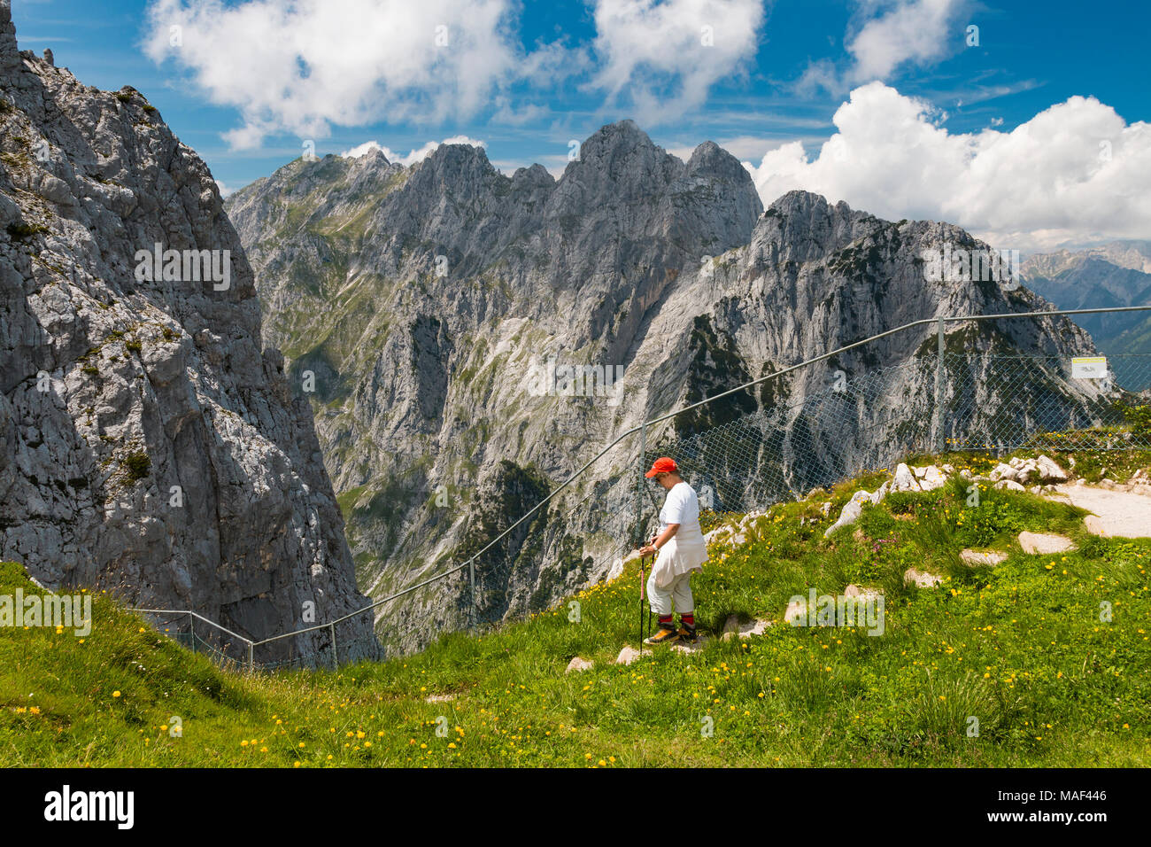 Una femmina senior escursionista su un sentiero all'Osterfelder Kopf vicino a Garmisch, Germania in estate con vista la stretta valle Hoellental Canyon . Foto Stock