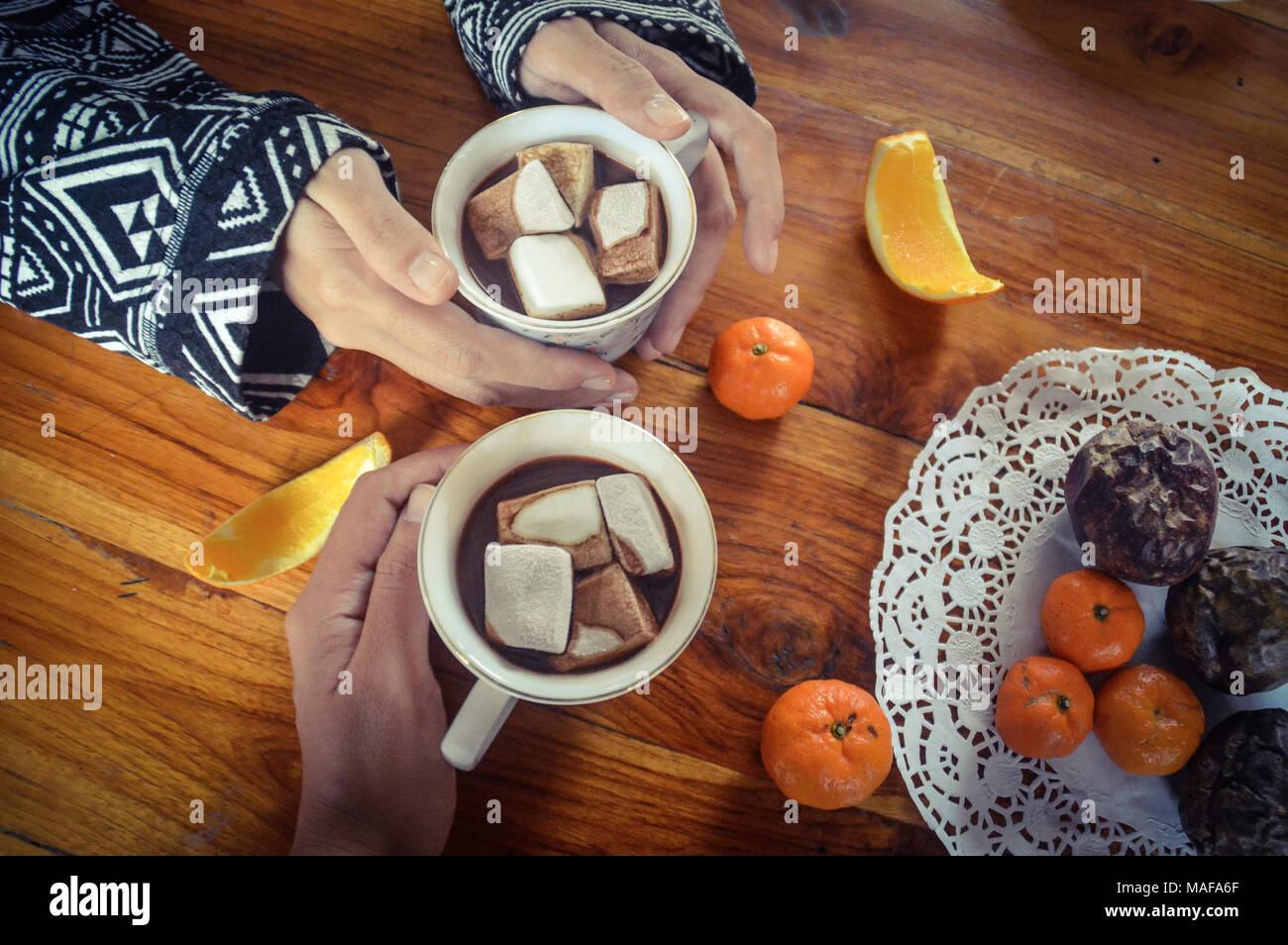 Condivisione di una tazza di cioccolata calda a bere con marshmallows in una fredda mattina presto Foto Stock