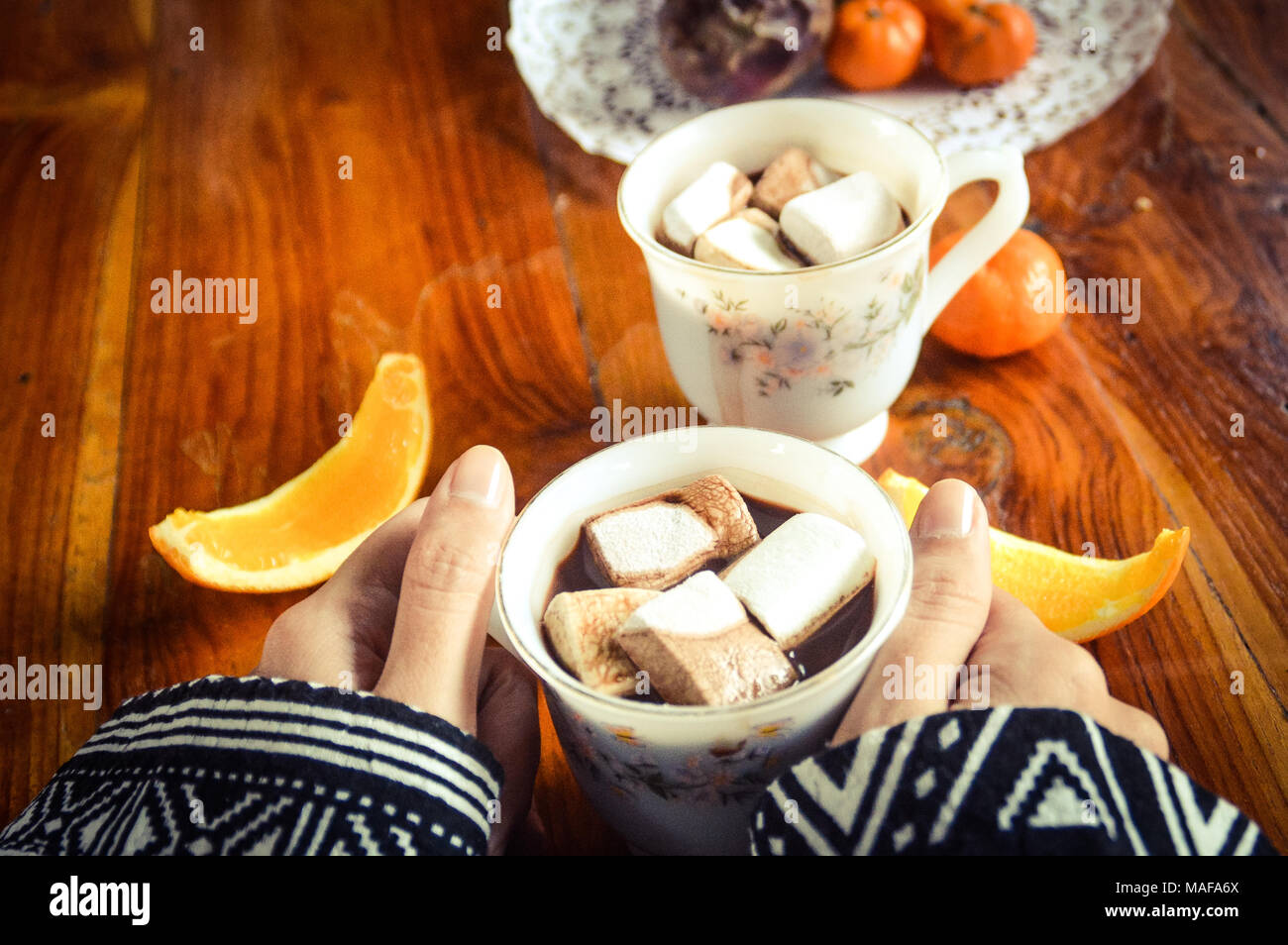 Condivisione di una tazza di cioccolata calda a bere con marshmallows in una fredda mattina presto Foto Stock