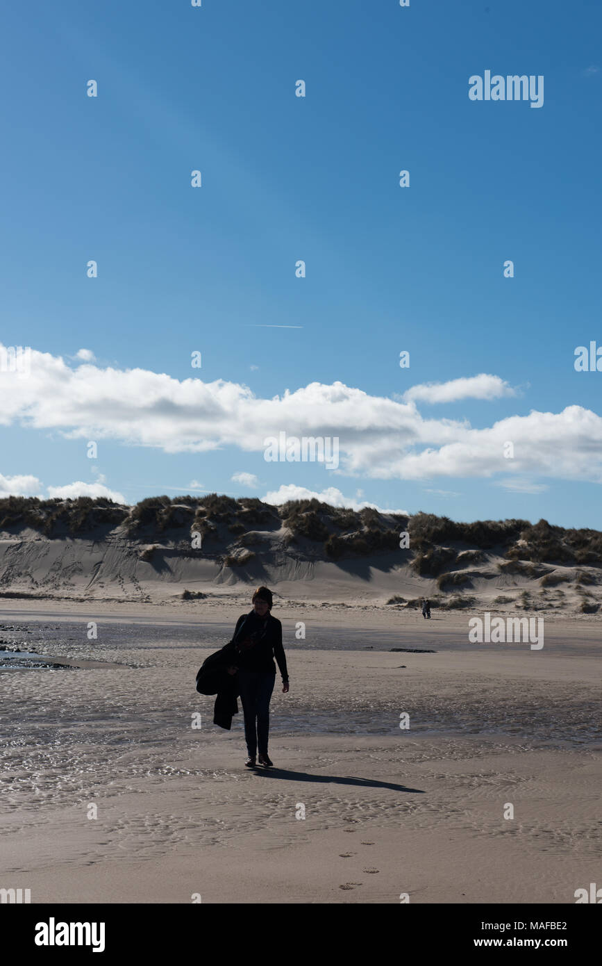 Primo piano di un'elica di una barca in ottone su un'imbarcazione nel bacino di carenaggio in un porto turistico, con persone che camminano sullo sfondo, in Inghilterra Foto Stock