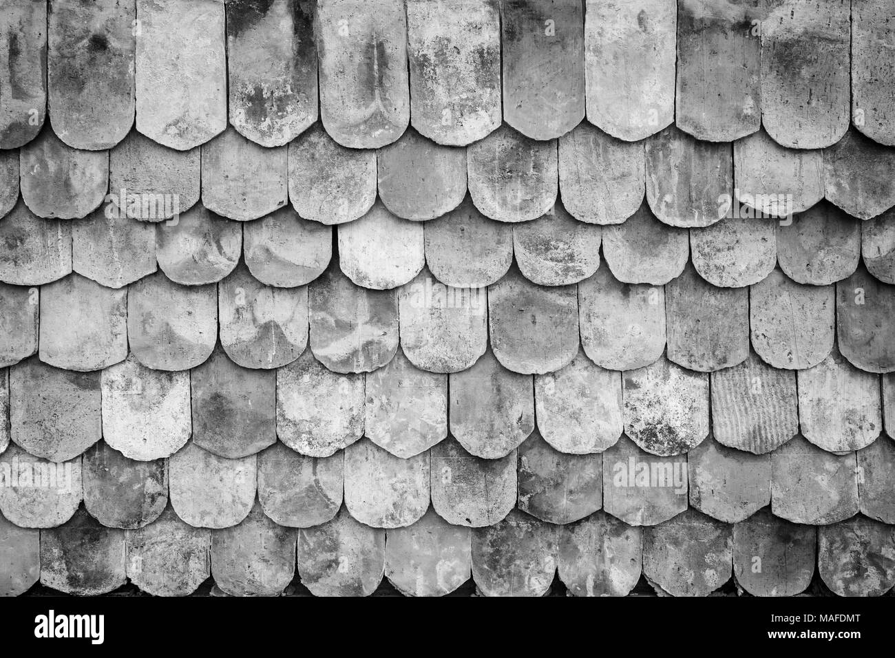 Close-up di vecchi e tetto a spiovente piastrelle sfondo texture con vignette in bianco e nero. Foto Stock