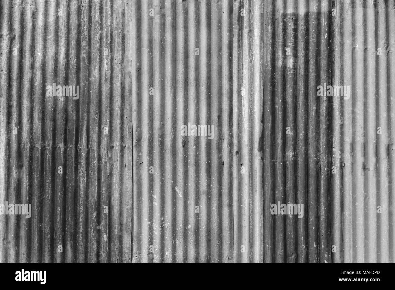 Rusty e ferro corrugato metallico sito di costruzione parete sfondo texture in bianco e nero. Foto Stock