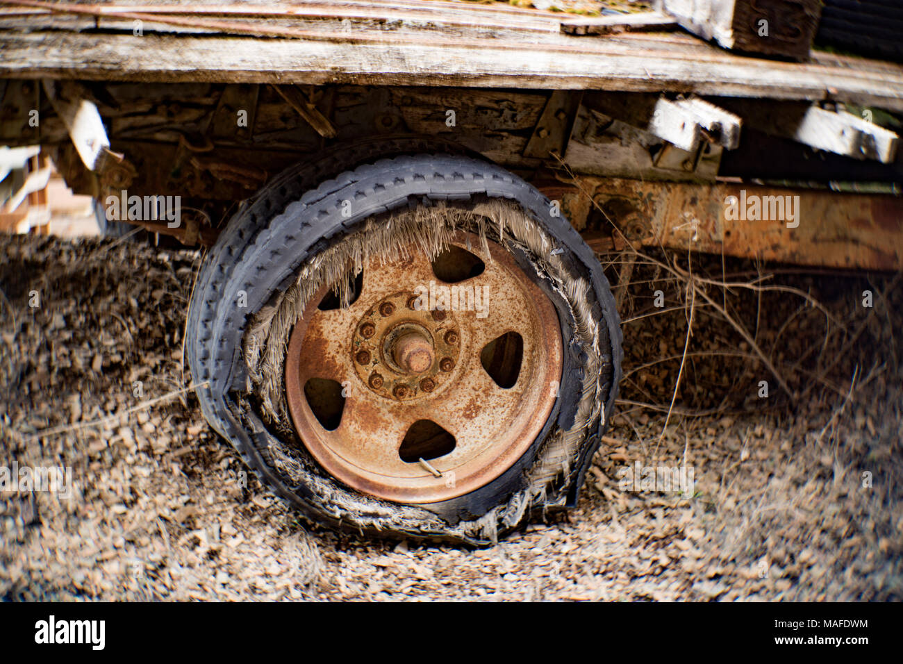 Un arrugginito 10 aletta ruota con una soffiata fuori a tele incrociate di pneumatico a heavy duty 1935 Chevy del carrello dello scanner a superficie piana, su di una collina in una vecchia cava di pietra, vicino a Clark Fork, Idaho Foto Stock