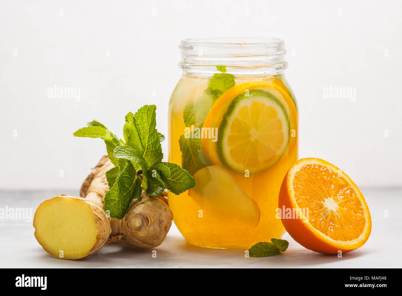 Lo zenzero orange ice tea alla menta in un barattolo di vetro, sfondo bianco, copia dello spazio. Estate bevanda rinfrescante concetto. Foto Stock