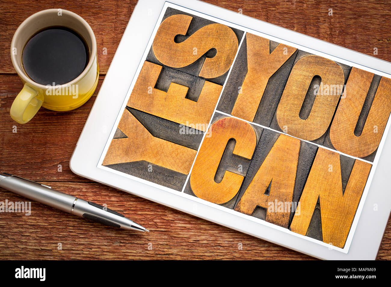 Sì è possibile - slogan motivazionale in rilievografia vintage tipo di legno su una tavoletta digitale con una tazza di caffè Foto Stock