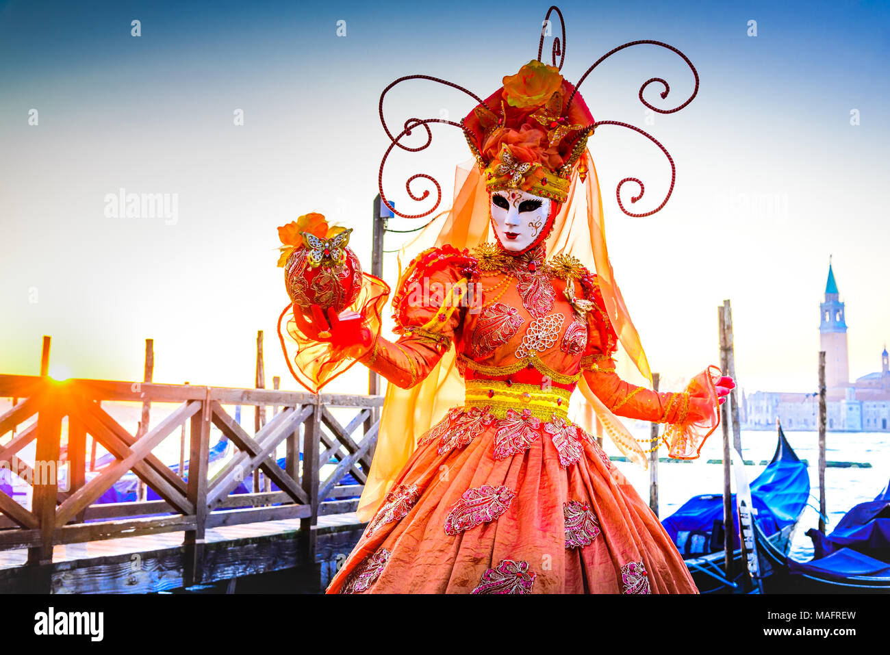 Venezia, Italia - 9 Febbraio 2018: il Carnevale di Venezia, bella maschera in Piazza San Marco con gondole e Grand Canal. Foto Stock