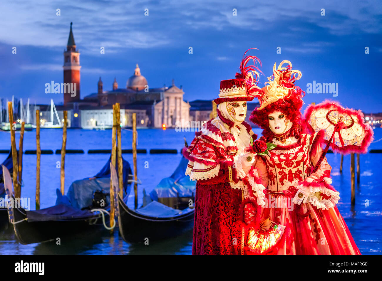 Venezia, Italia - 11 Febbraio 2018: il Carnevale di Venezia, bella maschera in Piazza San Marco con la Basilica di San Giorgio isola in background. Foto Stock