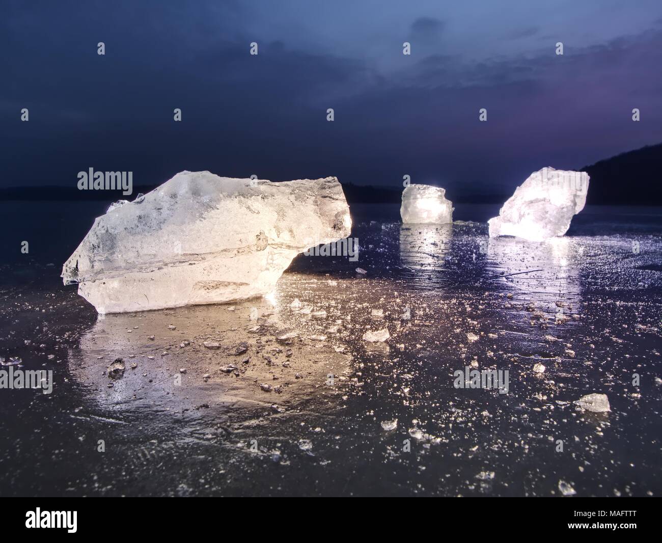 Vista in dettaglio in un ghiaccio con graffi profondi e crepe. Tagliare floe contro al cielo di sera e la luce spot. Foto Stock
