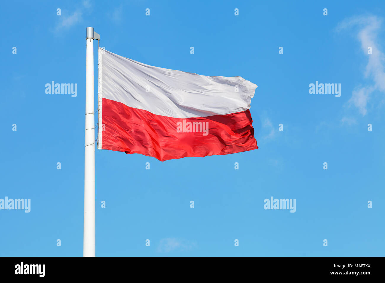 Nazionale Polacca di bandiera sventola sul vento contro blu cielo molto nuvoloso Foto Stock