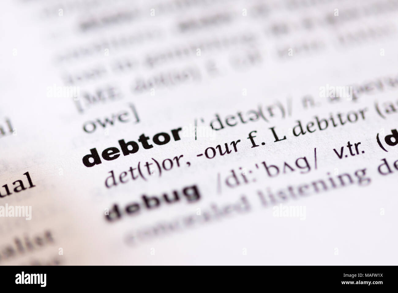 Una macro shot che mostra la definizione della parola debitore in un dizionario inglese Foto Stock