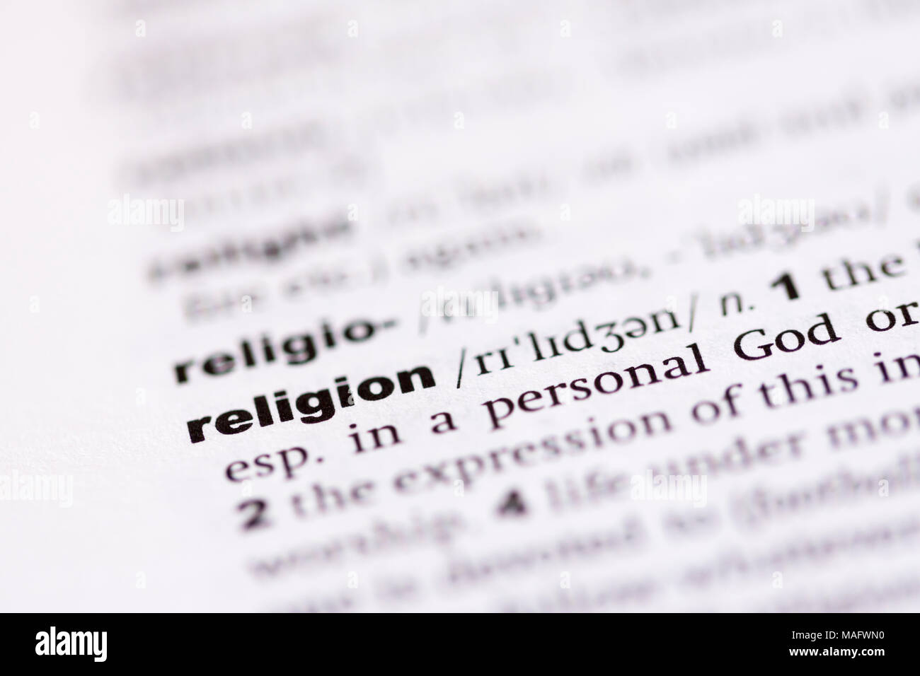 Una macro shot che mostra la definizione della parola religione in un dizionario inglese Foto Stock