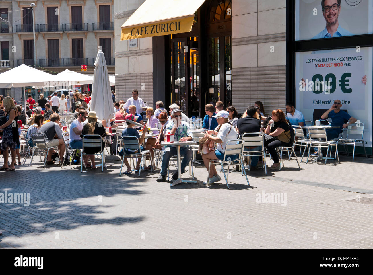 La gente seduta al di fuori di un cafe a La Rambla, Barcelona, Spagna Foto Stock