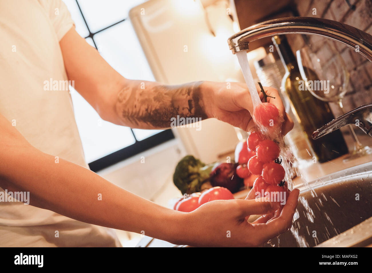 Norme in materia di igiene. Lavare le verdure e la frutta prima di mangiare o di cottura. Indoor, cucina home interno, studio shot. Foto Stock