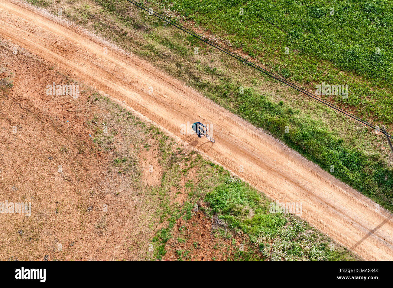 Ciclista su strada rurale Foto Stock