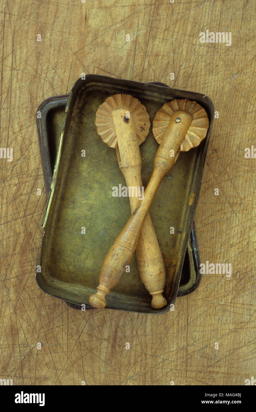 Due vintage pasta di legno taglierine giacente in ottone stagnati sul tagliere di legno Foto Stock