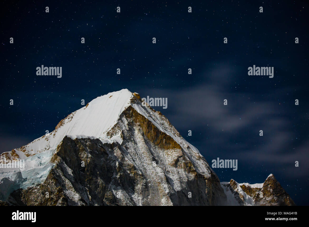 Snow capped lingtren montagna durante una notte stellata, campo base Everest, Himalaya, Nepal Foto Stock