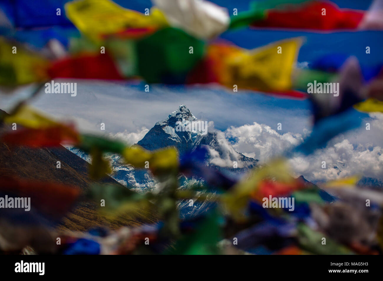 Pokhara di montagna come visto attraverso un colorato spray di preghiera nepalesi bandiere al vento. Himalaya, Nepal Foto Stock